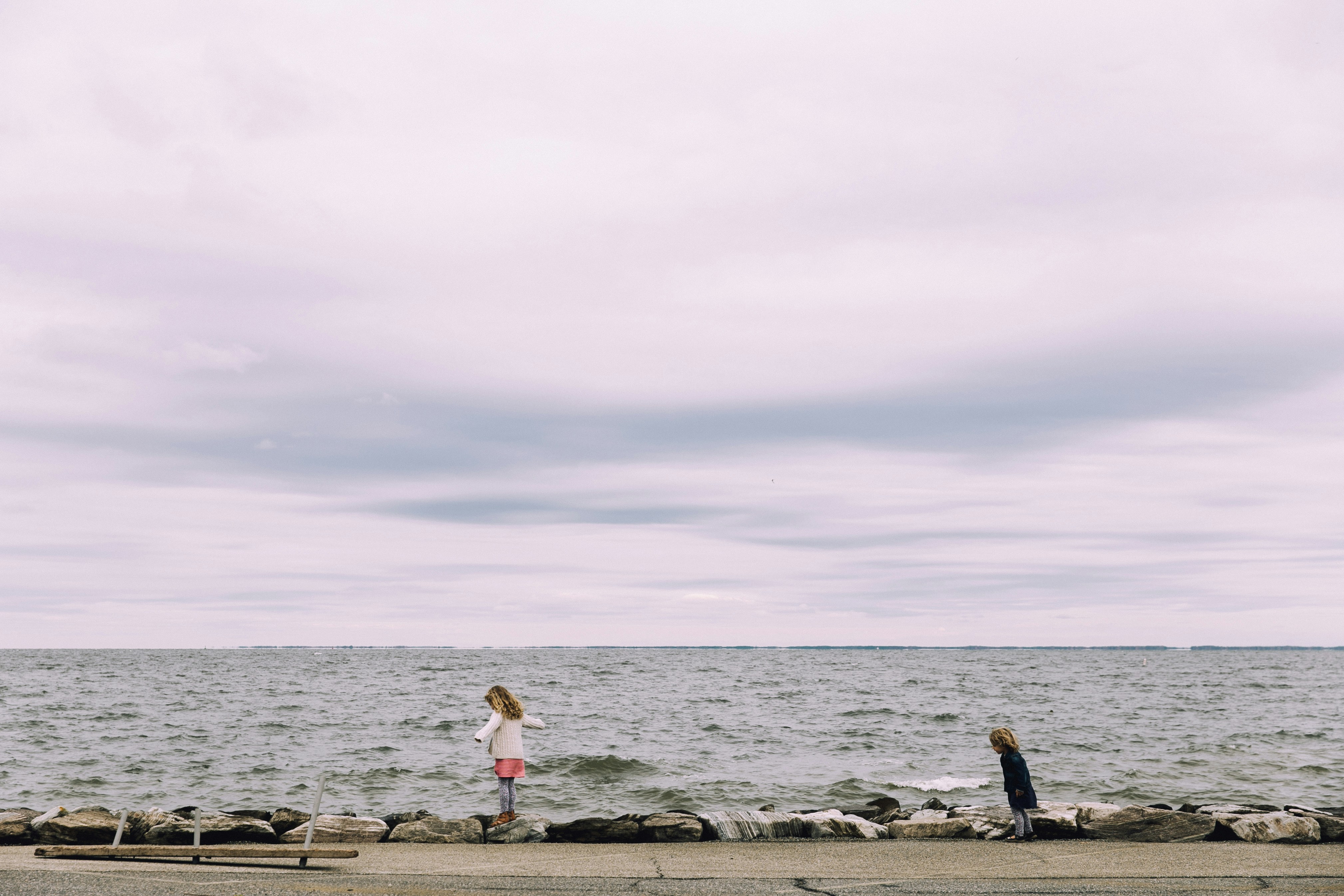 woman standing on cliff beside body of water