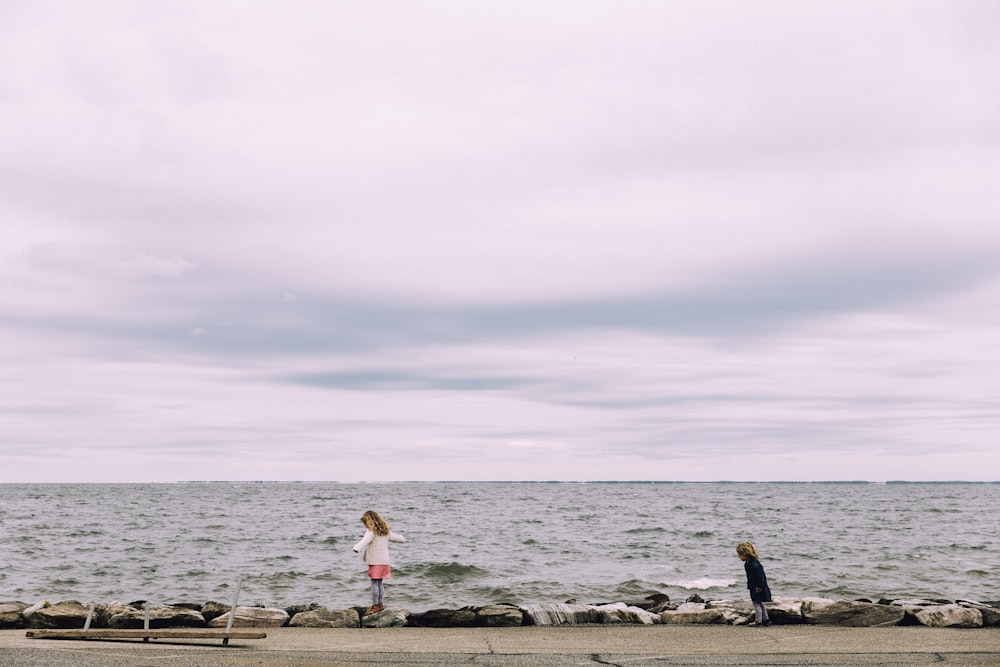 woman standing on cliff beside body of water