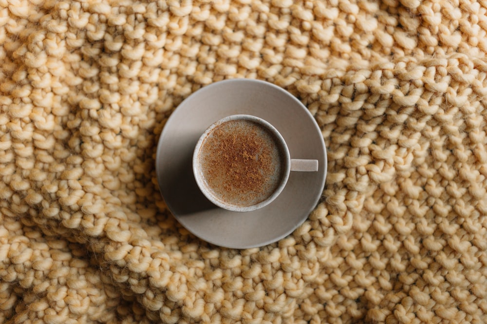 Taza de cerámica gris en platillo