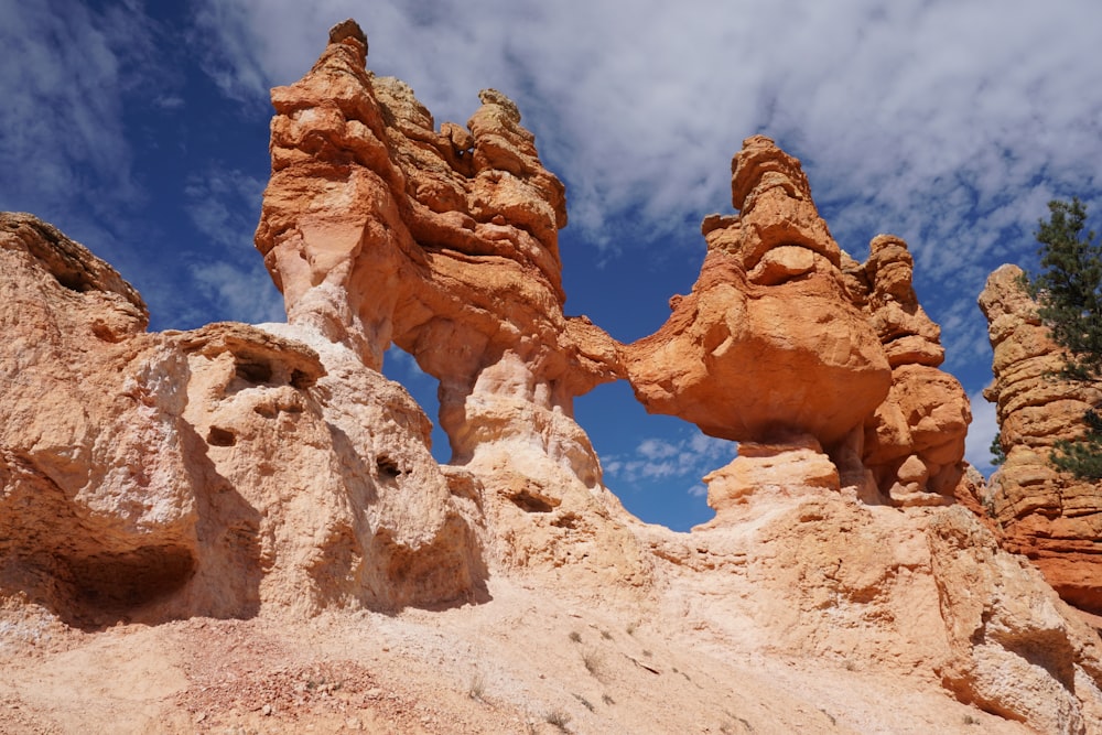 rock formation under blue and white cloudy sky