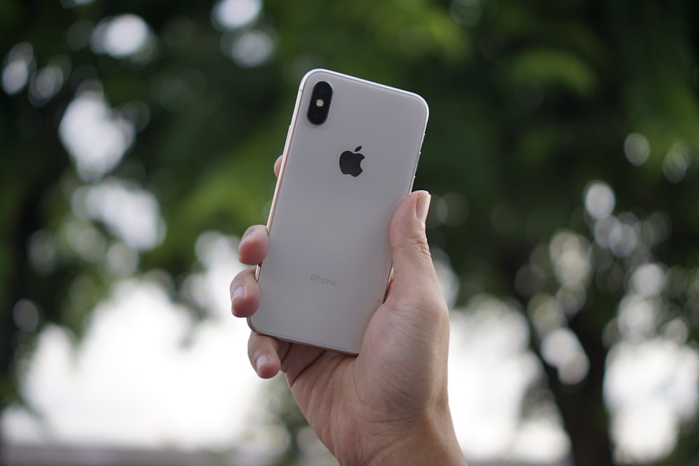 person holding silver iPhone X during daytime