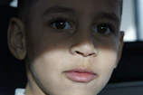 Close-up of a child’s curious eyes illuminated by gentle window light.