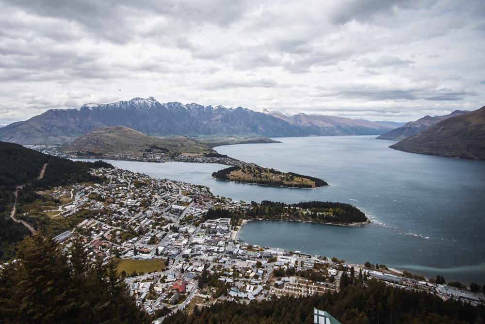 aerial photography of white houses near body of water under white clouds at daytime