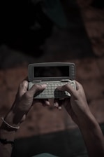 A close-up of a vintage smartphone held gently by hands, symbolizing care and history.