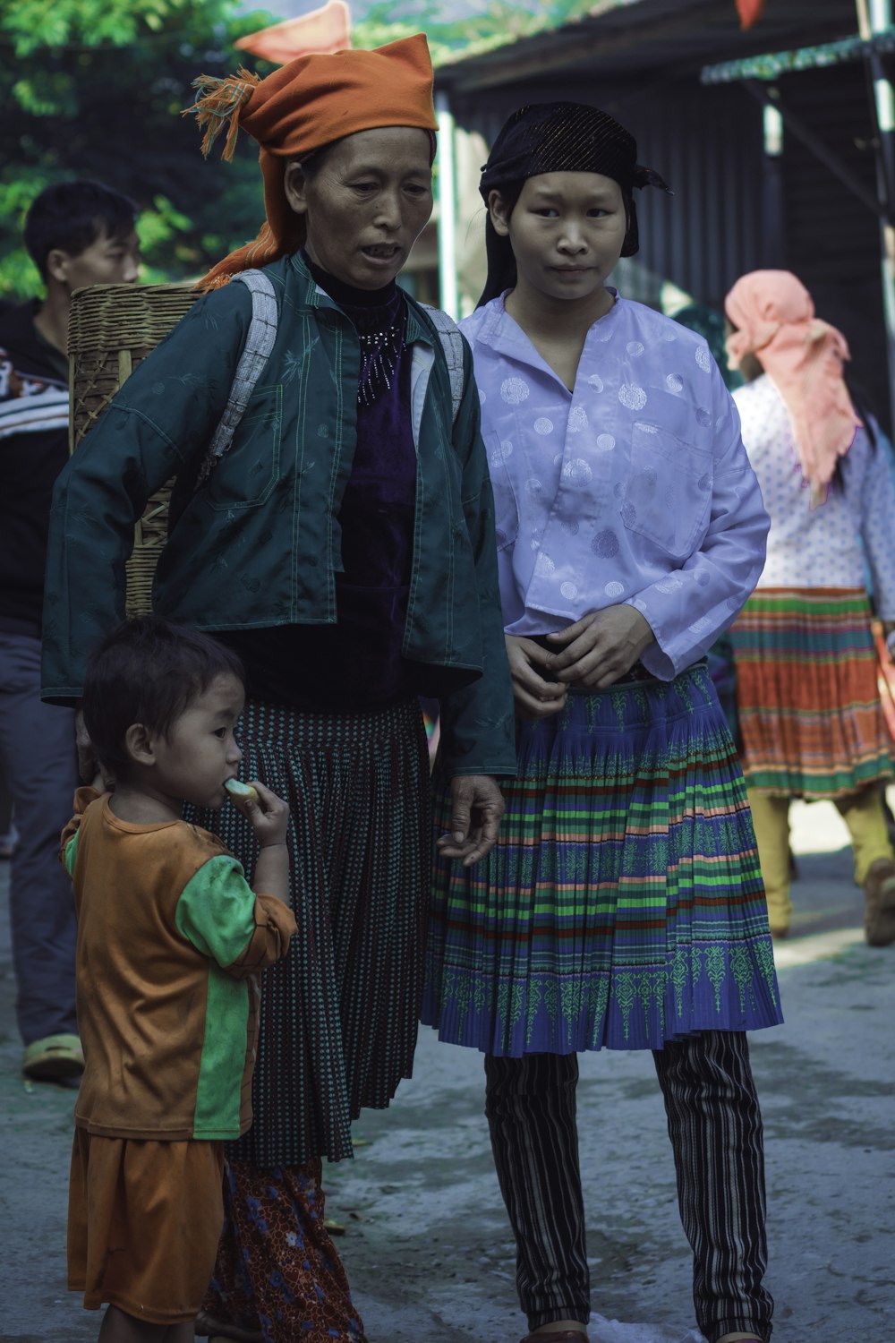 woman holding child beside woman wearing blue top