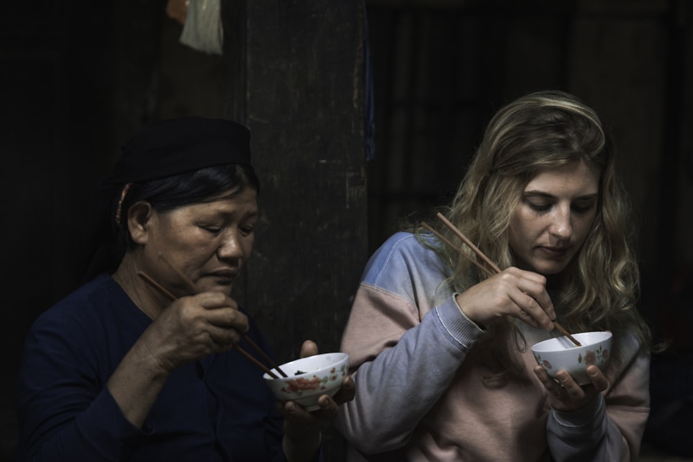 箸を使って食べる2人の女性
