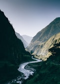 river between mountain at daytime
