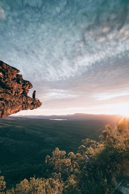 man sitting on mountain rock