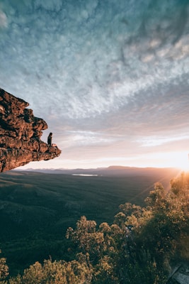 man sitting on mountain rock