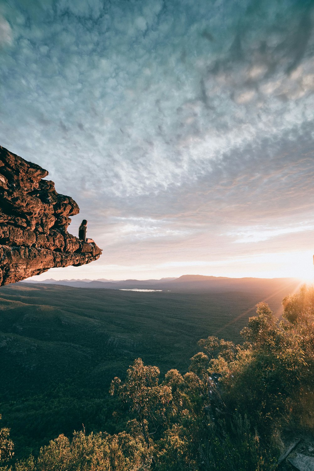 homme assis sur le rocher de la montagne