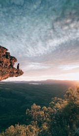 man sitting on mountain rock