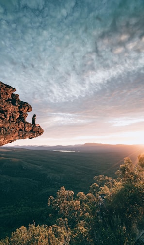 man sitting on mountain rock