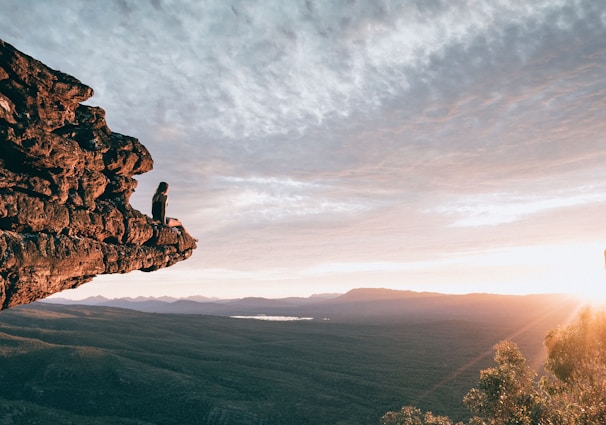 man sitting on mountain rock