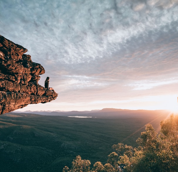 man sitting on mountain rock