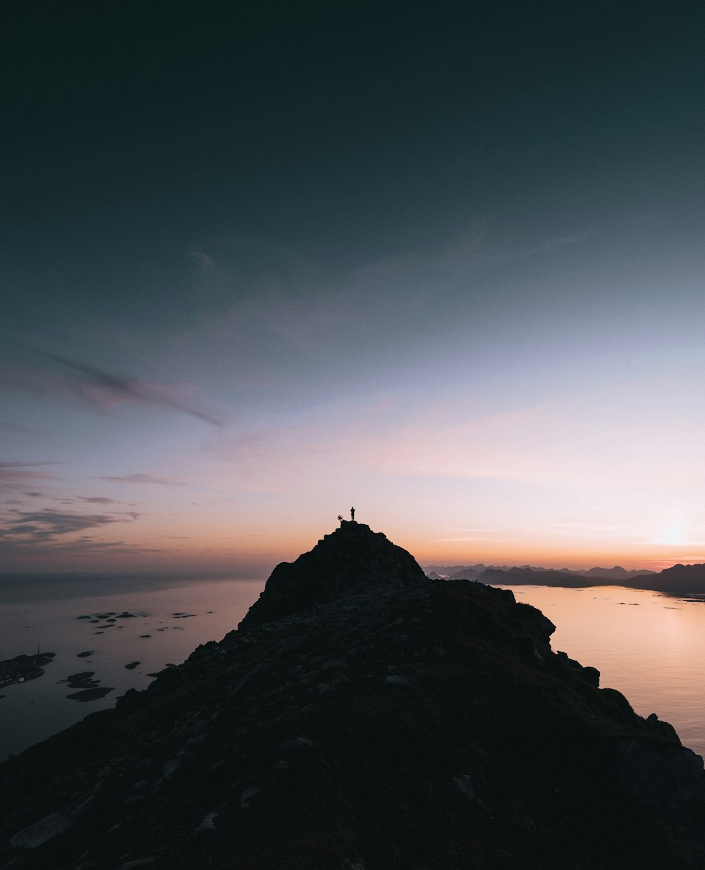 silhouette on person standing on top mountain cliff