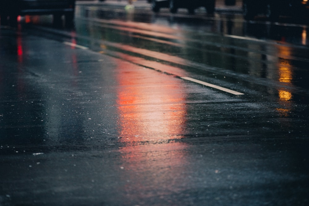 a wet street with a few cars parked on it