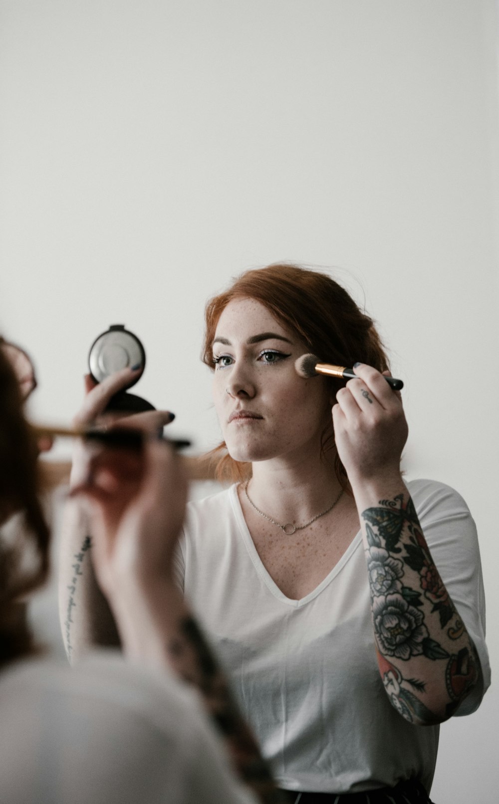 woman putting makeup on her face