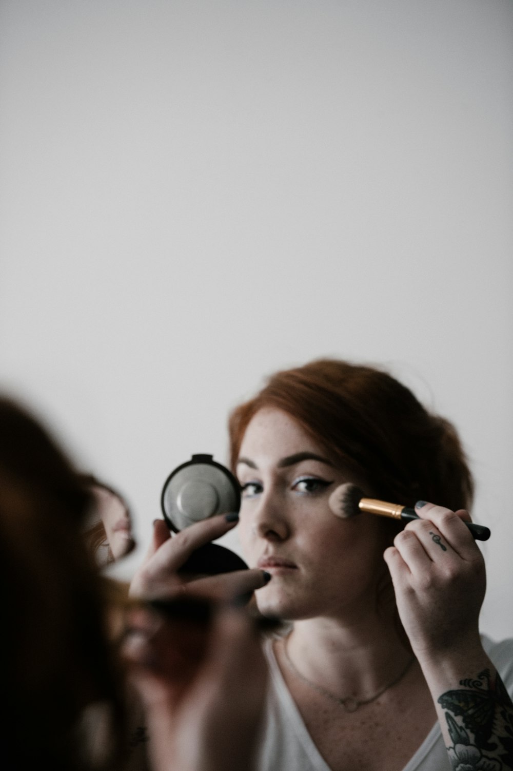 woman doing makeup infront of mirror