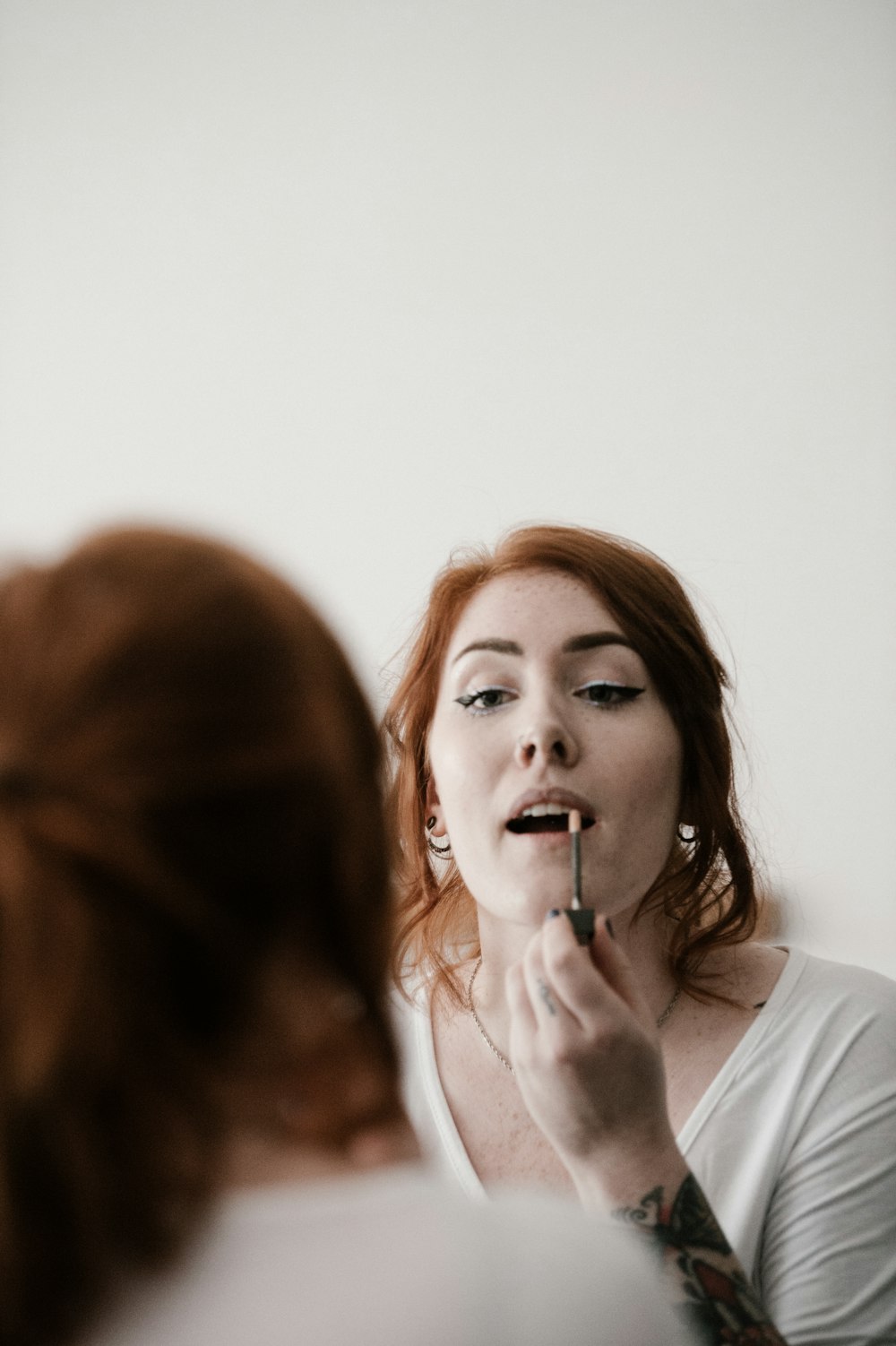 mujer poniéndose lápiz labial en los labios