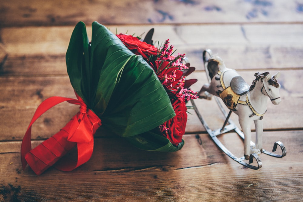 cavallo a dondolo accanto al mazzo di fiori