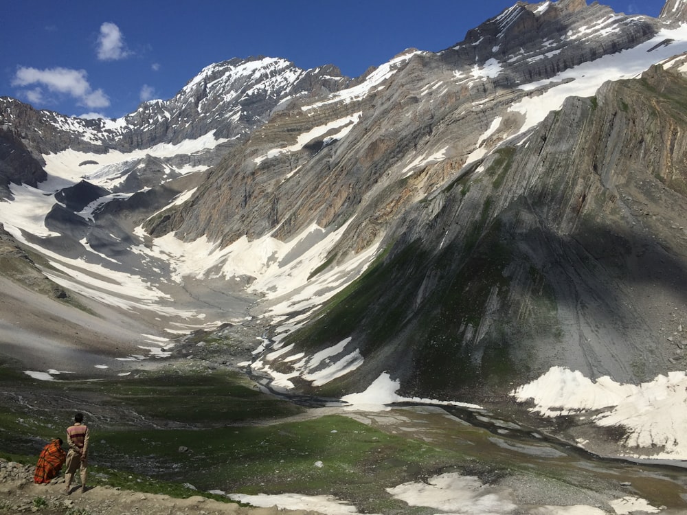 two person standing near mountain