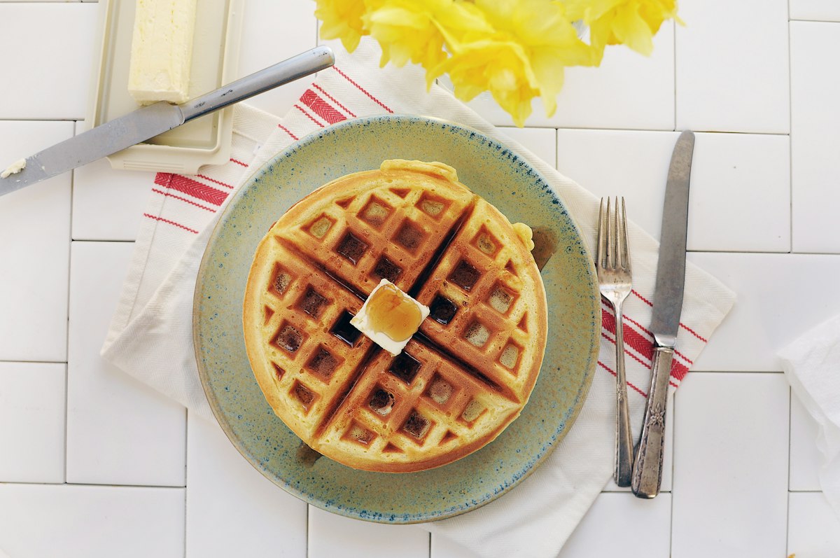 Waffle on a ceramic plate - compact waffle maker for a small apartment kitchen