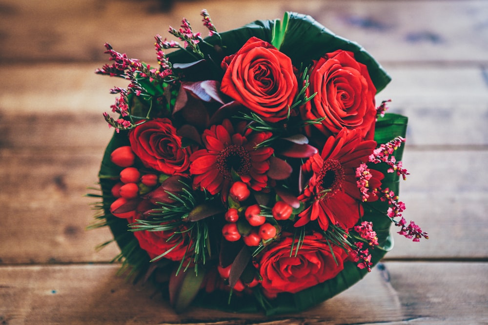 bouquet de fleurs rouges sur surface brune