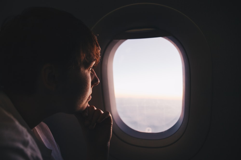 飛行機の中の窓を見ている男