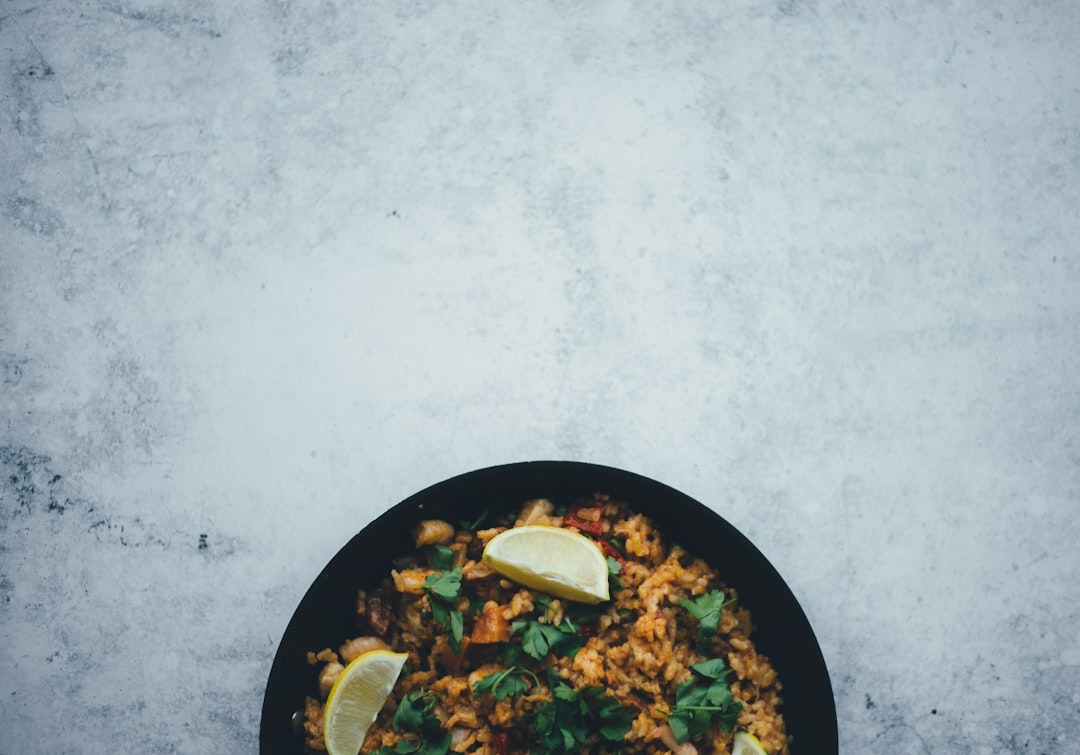 black ceramic bowl on gray concrete floor, Paella