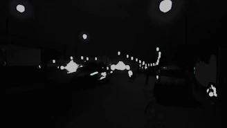 A tense small-town street scene at night, with flashing police lights hinting at a crime story.