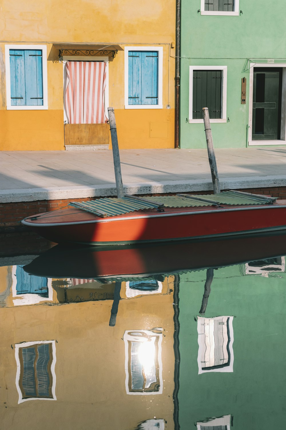 red and green boat docking on dock