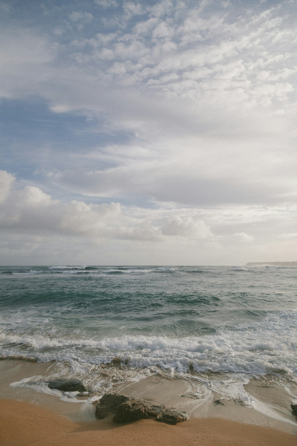 body of water under cloudy clouds