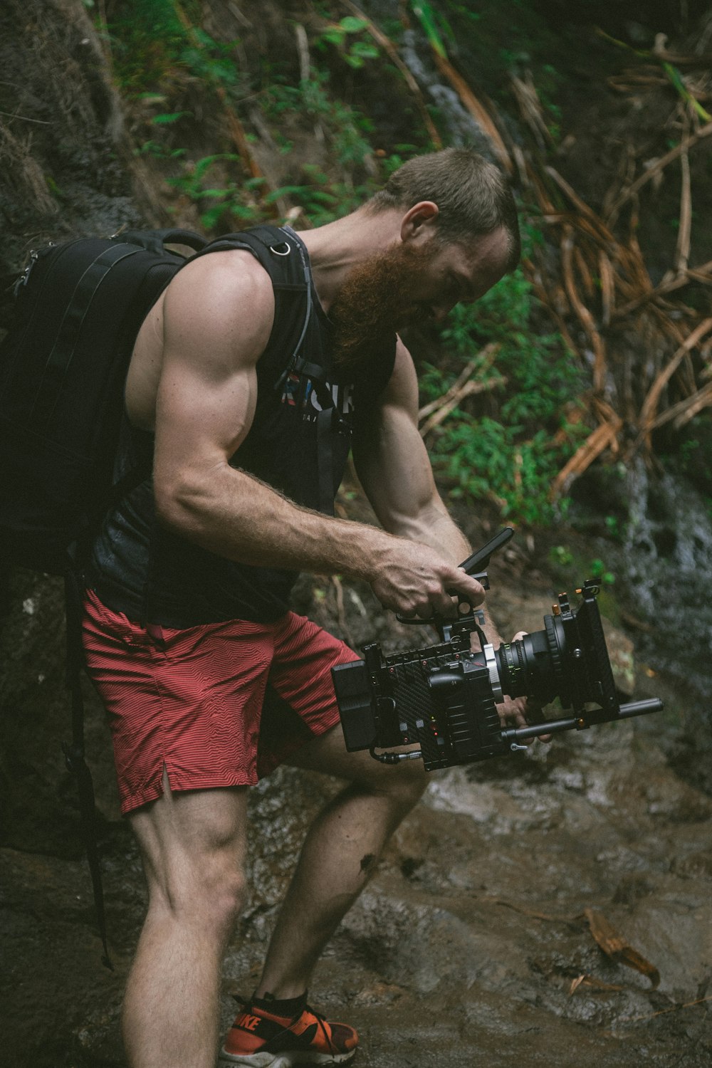 man holding black camera and backpack