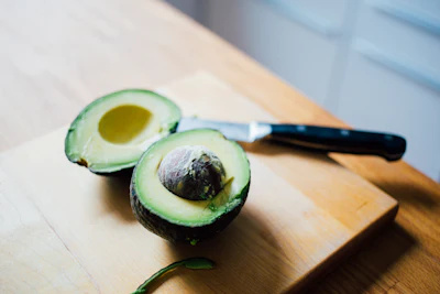 Halved avocado on a wooden cutting board