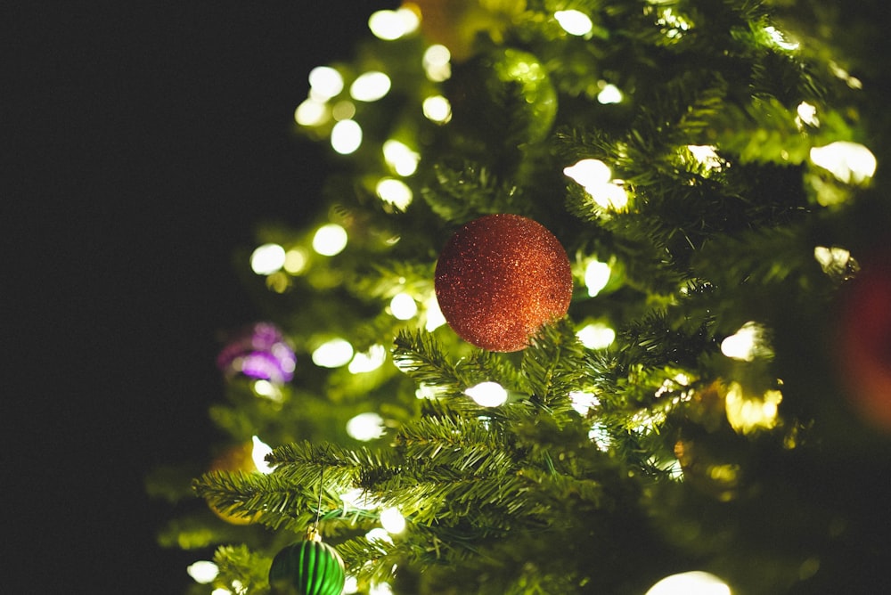 Decoração da bola laranja na árvore de Natal verde