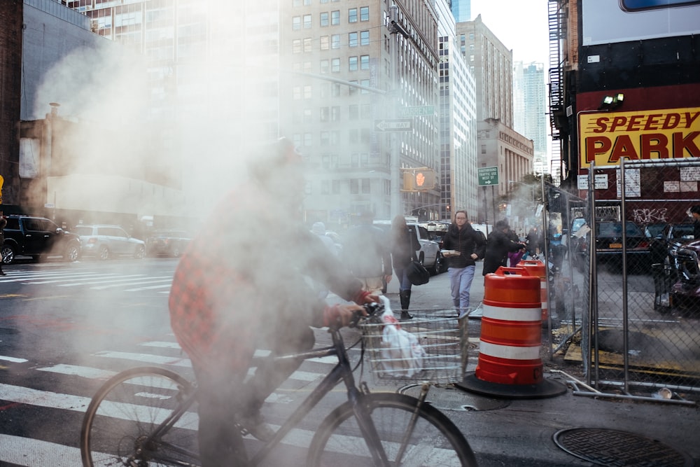 man riding bicycle on street during day time