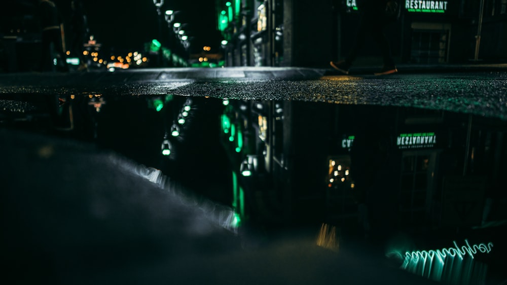 a reflection of a building in a puddle of water