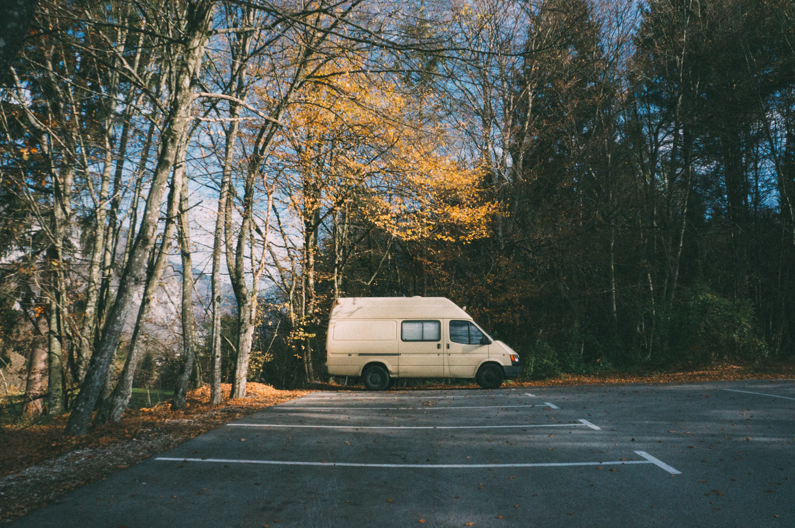 Camper parked in a marked lot beneath Slovenian mountains