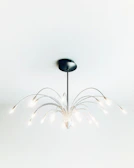 A modern chandelier with sleek metallic arms illuminating a stylish living space.