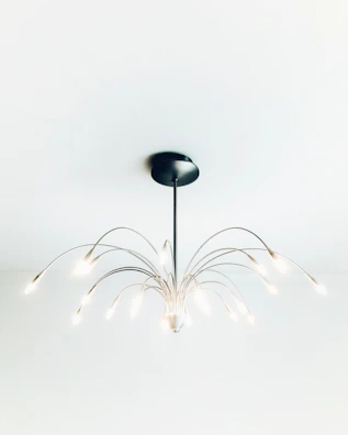 A modern chandelier with sleek metallic arms illuminating a stylish living space.