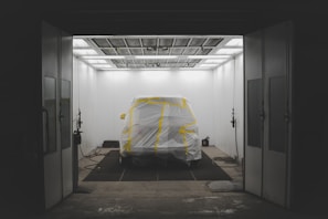 A car being painted in a professional spray booth.