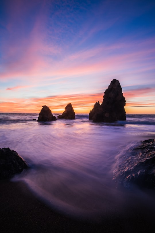 rock formations in body of water at blue hour in Rodeo Beach United States