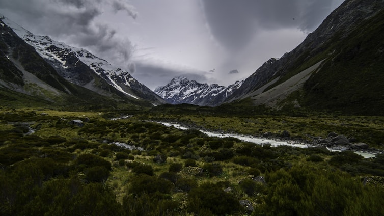 A serene landscape of Gilgit-Baltistan mountains under a soft green sky, symbolizing the spiritual roots of Noorbakhshia Islam.