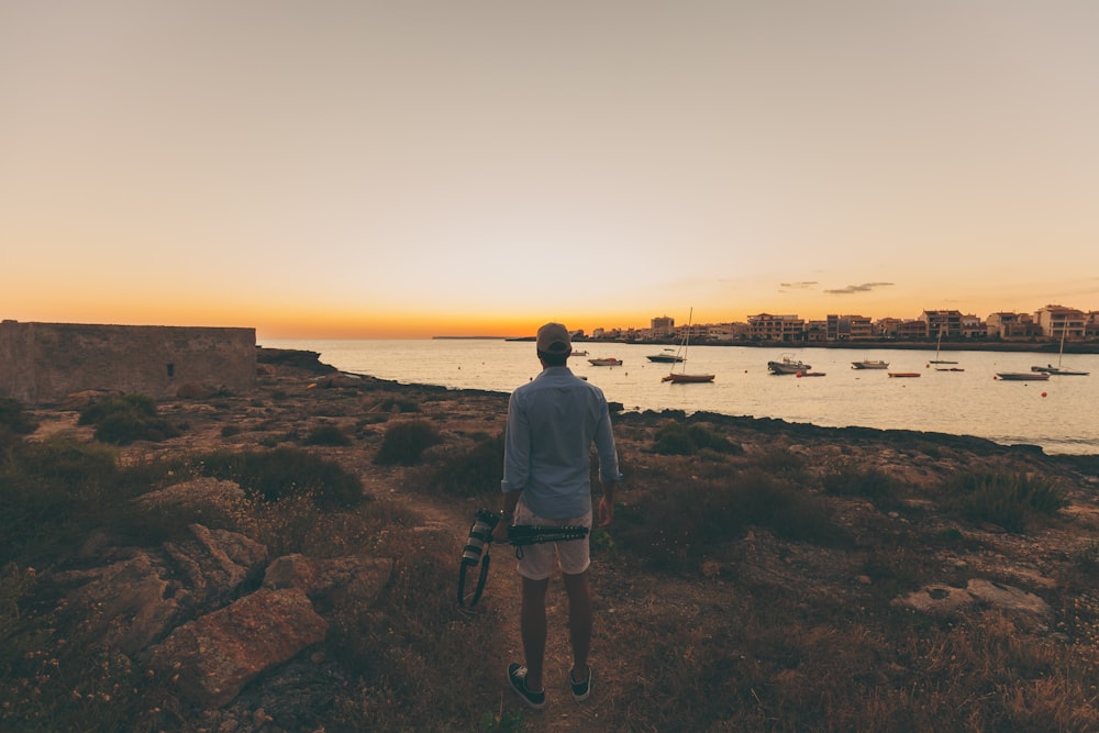 person standing in open area overlooking body of water