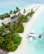 A secluded tropical island features a line of palm trees along a white sandy beach, with thatched roof structures integrated into the lush greenery. A seaplane is docked on the clear turquoise water near the shore, and a row of umbrellas with loungers extend along the beach.