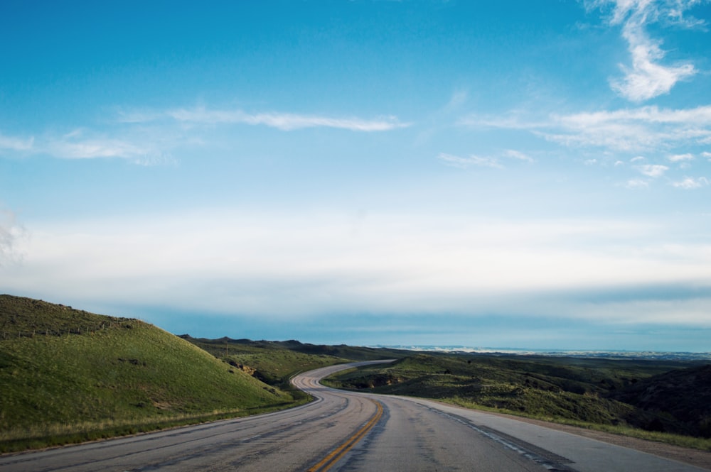 empty gray road under blue sky