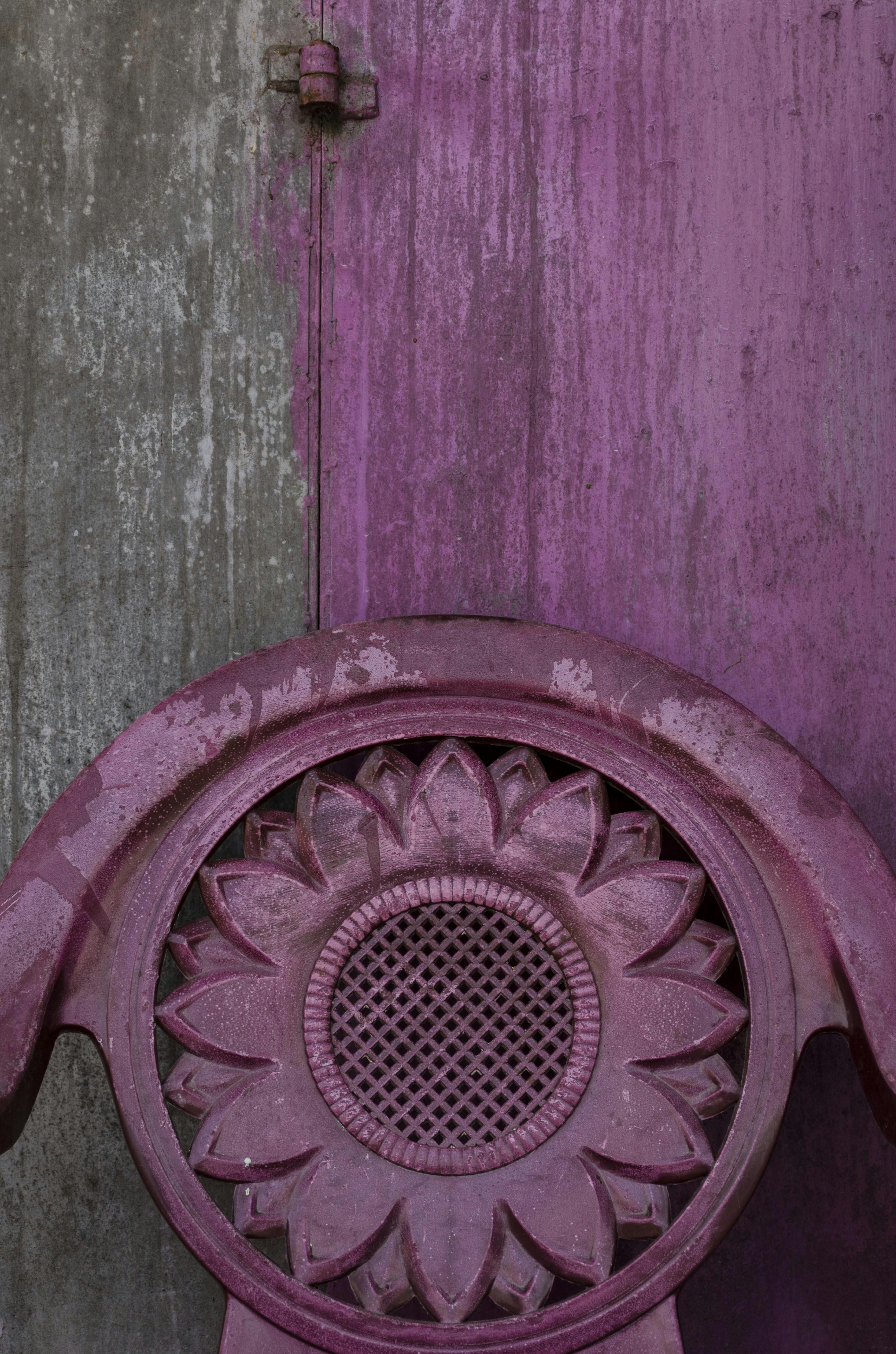 a purple chair sitting in front of a wooden door