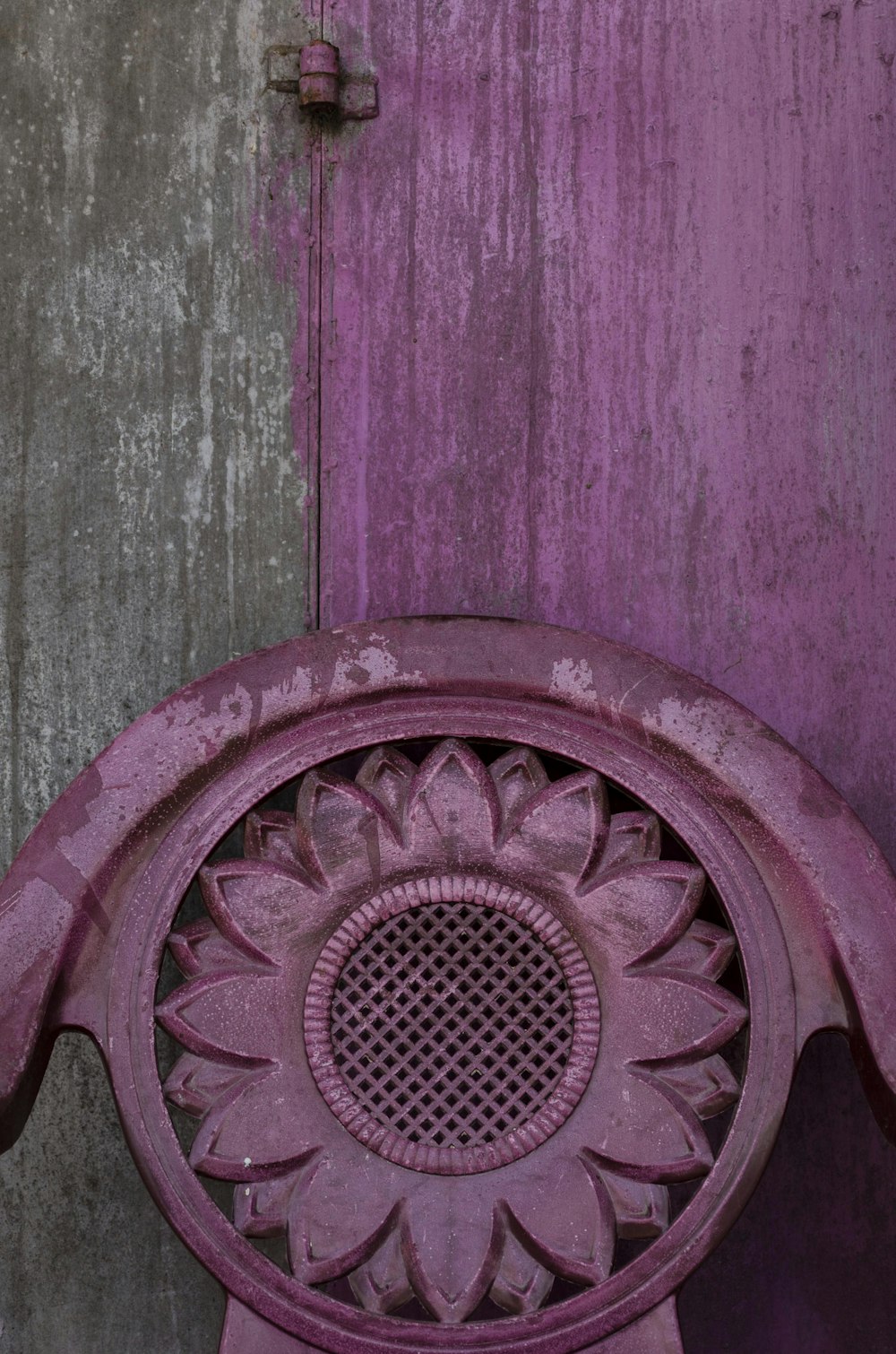 Ein lila Stuhl, der vor einer Holztür sitzt