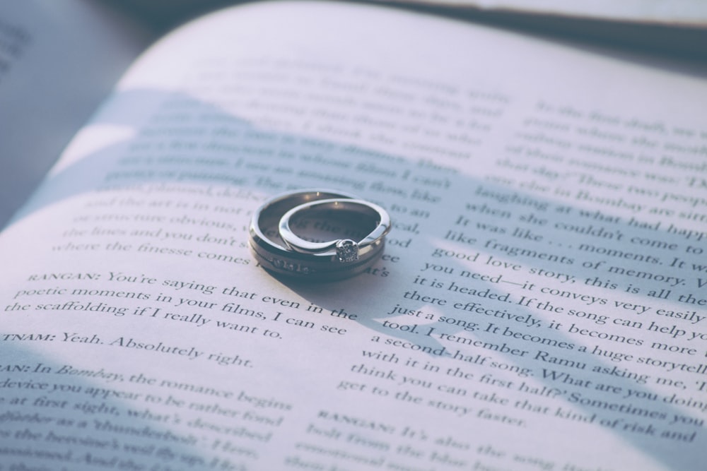silver-colored ring on top of book page