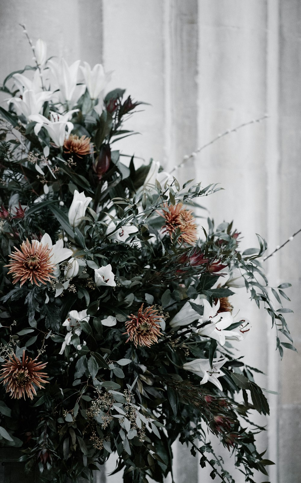 green, white, and brown flower arrangement decoration near white wall